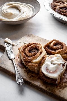 cinnamon rolls with icing on a cutting board