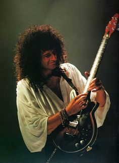 a man with long hair holding a guitar