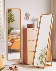 a mirror sitting on top of a wooden floor next to a dresser