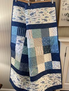 a blue and white quilt hanging on a clothes line