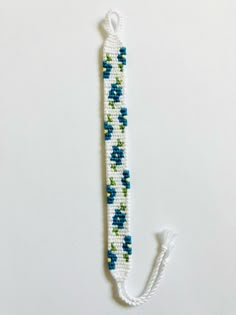 a white and blue beaded bracelet with an arrow on the end that is attached to a string