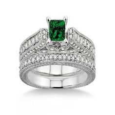 an emerald and diamond wedding ring set with matching engagement bands on the band, in 18k white gold