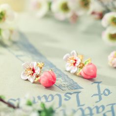 two pairs of pink and white flowers on top of a table with some writing in the background