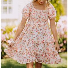 The Mary Anne Dress Is A Floral, Tiered Mini Dress Featuring A Smocked Top And Cuffed Sleeves. Floral Sundress With Smocked Bodice For Day Out, Mini Floral Dress With Smocked Back For Brunch, Floral Mini Dress With Smocked Back For Brunch, Spring Mini Length Smocked Dress With Floral Print, Summer Floral Dress With Smocked Bodice And Puff Sleeves, Summer Floral Mini Dress With Smocked Bodice, Summer Fitted Floral Dress With Smocked Back, Feminine Floral Dress With Smocked Back For Day Out, Fitted Floral Summer Dress With Smocked Back