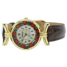 This elegant Murano glass watch is a unique timepiece featuring high-quality workmanship and the most famous Murano technique- Millefiori (a thousand flowers)- which has become a trademark of Murano glass making. Stylized flowers in beautiful colors grace the hand-made face of this watch and give it a trendy Venetian look. This Murano watch adds a perfect accent to any wardrobe and works equally well for a casual outing or a night on the town. The face of this Murano glass watch measures 1 inch Elegant Brown Watch For Gift, Elegant Multicolor Watches As Gifts, Elegant Multicolor Watches For Gifts, Elegant Round Jewelry With Leather Strap, Elegant Multicolor Round Dial Watches, Bohemian Handmade Murano Glass Necklaces, Handmade Adjustable Murano Glass Bracelets, Bohemian Multicolor Murano Glass Jewelry, Traditional Murano Glass Jewelry Gift