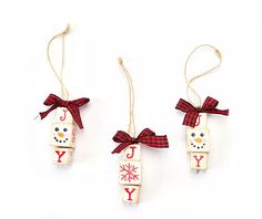 three christmas ornaments hanging from twine on white background