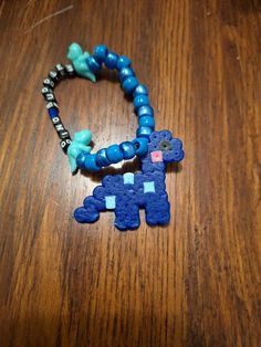 A bead bracelet with a perler Dino as a charm 8mm Round Beads Bracelets For Crafting, Beaded Charm Bracelet For Friendship, Toledo, Bead Bracelet, Charm Bracelets, Pixel Art, Labour Day, Jewelry Bracelets, Bathing Beauties