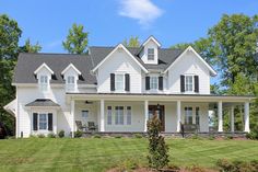 a large white house sitting on top of a lush green field