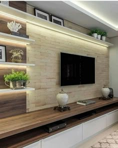 a living room with a large tv and built - in shelving units on the wall