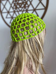 a woman with long blonde hair wearing a green knitted headband on her head