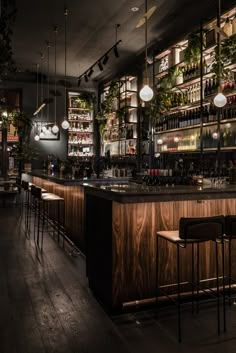 a dimly lit bar with lots of bottles on the shelves and lights hanging from the ceiling