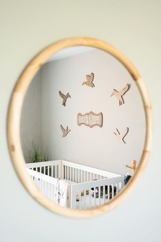 a baby's room with birds on the wall and a crib in the foreground