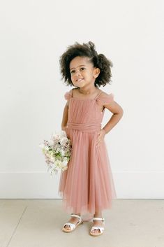 Our Rosalie Tulle dress is now even sweeter and available in our Kids collection! Rosalie Kids features a pleated bodice with a straight neckline for modest coverage, a self-tie tulle sash at the waist, and detachable off-the-shoulder sleeves. Convert the sleeves on and off with small buttons on the interior of the dress. Model Naveah; Size: 3T / Length: Regular, Age: 2, Height: 3'3 FEATURES: Flowy A-line silhouette Straight neckline Adjustable tulle spaghetti straps Back zipper Full-length doub Bridesmaid Dress With Ruched Tulle Bodice, Fitted Tulle Dress With Pleated Details, Fitted Tulle Dress With Pleats, Summer Pleated Tulle Dress, Fitted Pleated Tulle Dress, Pleated Tulle Summer Dress, Pink Flowy Dress, Champagne Flower Girl, Tulle Bodice