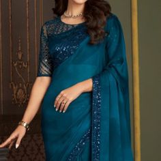 Teal Blue colored saree is prettified with sequins work as shown which makes it appear classy. This saree is made of chiffon fabric which is accompanied with banglori silk blouse piece which you can customise as per your design/style. Women can buy this saree to wear for their parties, reception and events. Note:- The actual product may differ slightly in color and design from the one illustrated in the images when compared with computer or mobile screen. Measurements: Saree : Chiffon : 5.5 Mtrs Blouse : Chiffon : 0.8 Mtr Material: Chiffon Stitch Type: Unstitched Country of Origin: India Care Guide: Dry Clean Blue Pre-draped Saree With Resham Embroidery For Party, Blue Georgette Pre-draped Party Saree, Traditional Blue Pre-draped Saree With Sequins, Blue Georgette Party Pre-draped Saree, Traditional Blue Sequined Pre-draped Saree, Blue Resham Embroidery Blouse For Evening, Blue Festive Saree For Evening, Blue Sequined Blouse Piece For Wedding, Festive Blue Saree For Evening Occasions