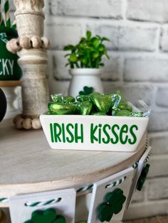 a bowl filled with green candy sitting on top of a table next to potted plants