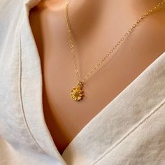 A beautiful small, shiny gold flower with lots of detail is hung on a delicate yet sturdy 14K Gold-Filled Chain. Sweet and simple. Feminine and charming. - Pendant - 14k Gold plated Brass - 9mm in diameter - Chain + components - 14K Gold-Filled - Clasp - 14K Gold-Filled lobster clasp . . . . . . . . . . . . . . . . . . . . . . . . . . . . . . . .  Want more for bridesmaids, sisters or friends? I am happy to put custom orders together! . . . . . . . . . . . . . . . . . . . . . . . . . . . . . . . .  Necklace arrives packaged for giving. Delicate Tiny Gold Jewelry, Gold Flower Necklace In 14k Gold, Gold Flower Charm Pendant Necklace, Delicate Flower Charm Necklace With Delicate Chain, Tiny Gold Flower-shaped Jewelry, Gold Pendant Flower Necklace With Flower Charm, Gold Flower Pendant Necklace For Anniversary, Gold Necklace With Flower Charm, Yellow Gold Flower Charm Necklace For Anniversary