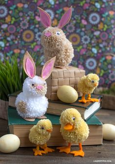 stuffed animals are sitting on top of books with easter eggs in front of the book