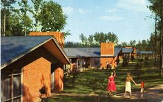 two women and a child are walking in front of a brick house on a sunny day