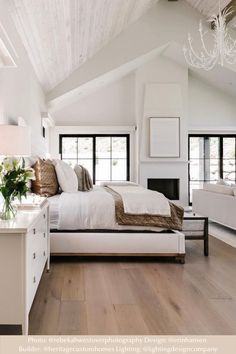 a bedroom with white furniture and wood floors