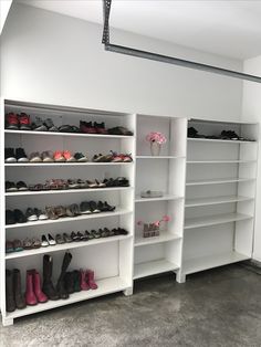 there are many pairs of shoes on the shelves in this room, all lined up