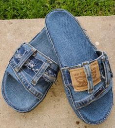 two pairs of blue jean slippers sitting on top of a cement slab