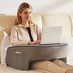 a woman sitting on a bed using a laptop