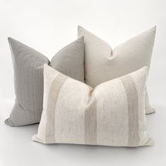 two pillows sitting next to each other on a white surface