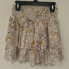 Cream Floral Skirt With Yellow Purple And Brown Flower Design And Textured Fabric Super Cute Layered Floral Skirt Perfect For Summer And As A Beach Or Pool Coverup Perfect Condition Never Worn Completely New Elastic Waist Super Comfy And Flattering Size M Length About 13.5 Inches Waist About 11.5 No Damage, Rips Or Stains From A Smoke Free And Pet Free Clean Household Reasonable Offers Are Welcome :) Feel Free To Ask Me Questions Below White Bohemian Mini Skirt With Floral Print, Bohemian White Mini Skirt With Floral Print, Yellow Tiered Skirt With Floral Print, Yellow Ruffled Bottoms For Vacation, Yellow Skirted Bottoms With Elastic Waistband, Yellow Ruffled Mini Skirt For Summer, Yellow Ruffled Mini Skirt For Spring, Yellow Tiered Mini Skirt For Summer, Flowy Yellow Ruffled Skirt