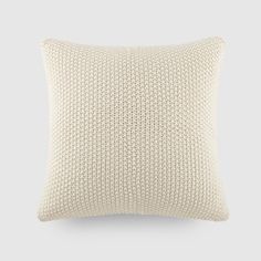 a white knitted pillow on a gray background