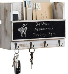 a chalkboard with keys hanging from it and a key holder attached to the wall