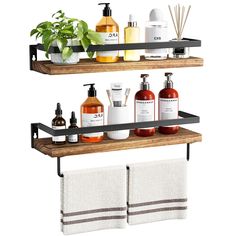 two wooden shelves with towels, soaps and lotion bottles on them in front of a potted plant