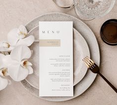 a plate with a menu on it next to a cup and saucer filled with flowers