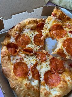 a pepperoni pizza in a box with one slice missing from it's crust