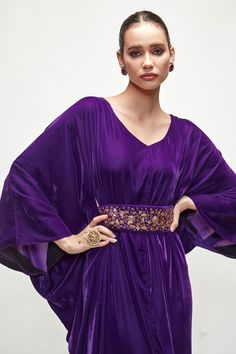 Violet cowl draped kaftan with V neckline. Paired with zardozi work belt.
Component: 2
Neckline: V Neck
Sleeve Type: Flared Sleeves
Fabric: Velvet
Color: Purple
Other Details: 
Embroidered belt
Occasion: Mehendi and Haldi - Aza Fashions Festive Bollywood Style Evening Abaya, Festive Bollywood Evening Abaya, Formal Festive Maxi Length Kaftan, Festive Evening Gown With Dabka Detailing, Festive Formal Maxi Length Kaftan, Bollywood Style Evening Abaya, Bollywood Style Party Abaya With Traditional Drape, Bollywood Style Dabka Evening Dress, Bollywood Dabka Evening Dress