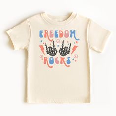 "Introducing our vibrant and playful kids 4th of July tee that proudly declares \"Freedom Rocks!\" This adorable and spirited shirt is designed to capture the imagination and energy of young minds while celebrating the timeless value of freedom. -BODYSUIT- .: 100% combed ringspun cotton  .: Infant unisex fit .: Light fabric (5.0 oz/yd² (170 g/m .: Tear-away label -TODDLER & YOUTH TEE- .: 100% Airlume combed and ring-spun cotton  .: Extra light fabric (4.2 oz/yd² (142 g/m .: Retail fit .: Tear-away label  Various factors such as your screen resolution, color settings, display type, lighting conditions during photoshoot, and the fact that each person sees colors differently, can all affect how the colors are displayed on the Internet. Consequently, actual colors may slightly vary. If you lik Playful T-shirt For 4th Of July With Crew Neck, Playful Crew Neck T-shirt For 4th Of July, Fun 4th Of July Graphic Print T-shirt, 4th Of July Fun Graphic Print T-shirt, Playful White T-shirt For 4th Of July, 4th Of July Birthday T-shirt With Graphic Print, Graphic Print T-shirt For 4th Of July Birthday, Casual 4th Of July Birthday T-shirt, Cute 4th Of July Birthday T-shirt