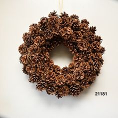 a pine cone wreath hanging on a wall