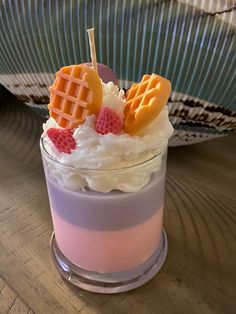 a dessert with whipped cream and waffles in a glass on a wooden table