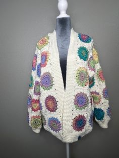 Handmade, crocheted, sweater, cardigan, cream and bright pastel colors, sunburst granny square, medium weight,  new Size large Colorful Granny Square Sweater For Spring, White Bohemian Cardigan With Granny Square, White Granny Square Cardigan For Spring, White Crochet Sweater One Size, White Granny Square Sweater For Winter, Bohemian White Outerwear With Granny Square Details, Bohemian White Outerwear With Granny Square, Cozy Cream Crochet Sweater, Cozy Multicolor Granny Square Sweater