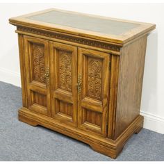 an old wooden cabinet with glass doors on the top and bottom, sitting in a room