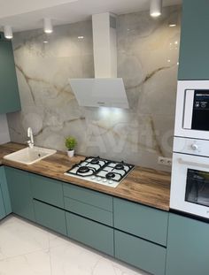 a kitchen with green cabinets and marble counter tops, white appliances and an oven in the corner