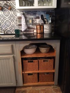 a kitchen with some baskets under the counter