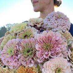 a woman is holding a large bouquet of flowers