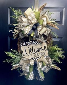 a welcome to our home wreath hanging on the front door with leopard print ribbon and bow