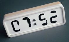 a white and black clock with the word cafe on it's display panel,