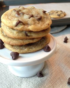 a stack of chocolate chip cookies sitting on top of a white plate