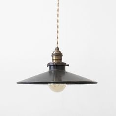 an industrial style light hanging from a ceiling fixture with a rope attached to the bulb