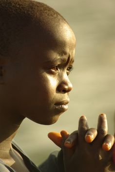 a close up of a person holding something in their hand and looking off into the distance