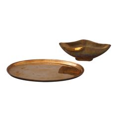 two brass dishes on a white background