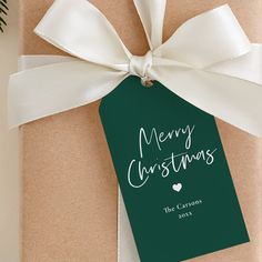 a present wrapped in brown paper with a white ribbon and tag that says merry christmas