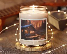 a lit candle sitting on top of a wooden table next to a string of lights